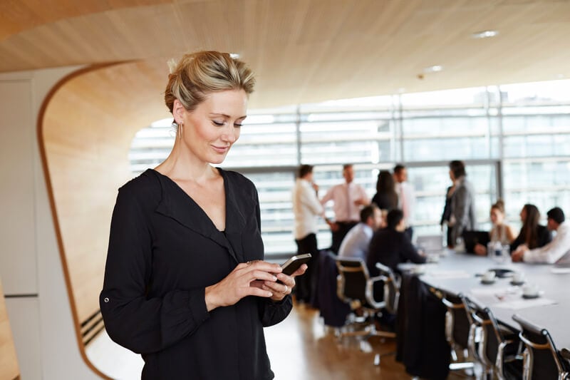 Businesswoman_using_smartphone_in_conference_room (1)