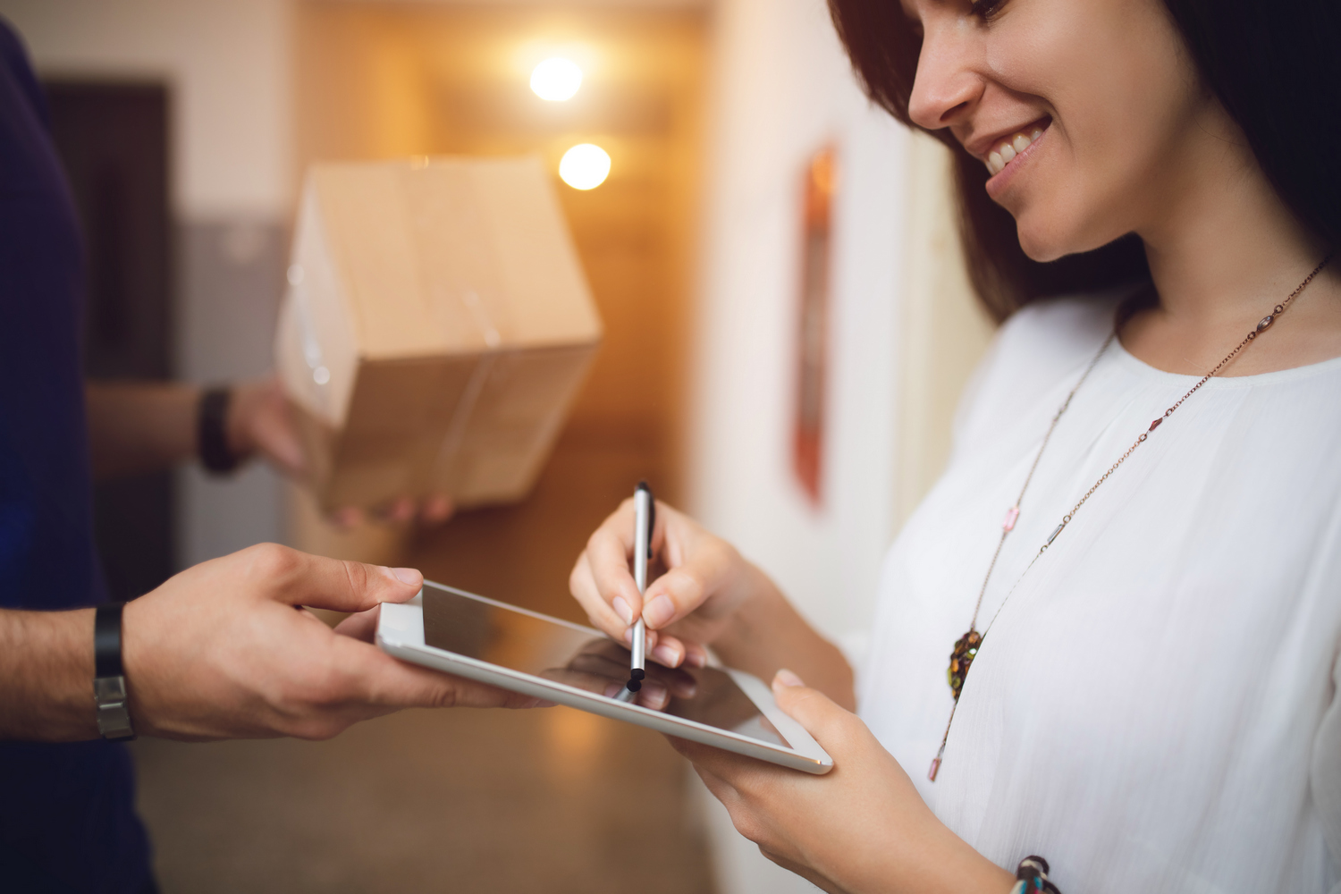 Postman delivering package to a woman at the door